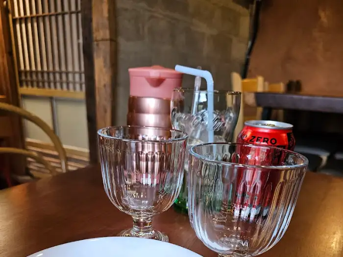 유리잔과 캔음료가 놓인 테이블