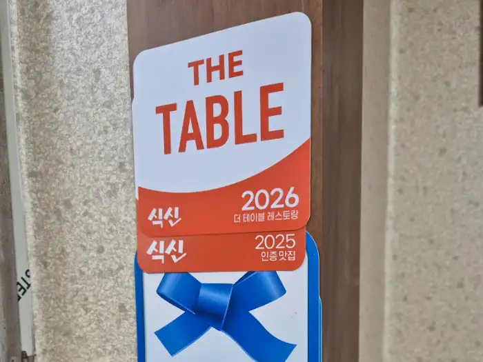 가게 앞에 부착된 'THE TABLE' 인증 스티커