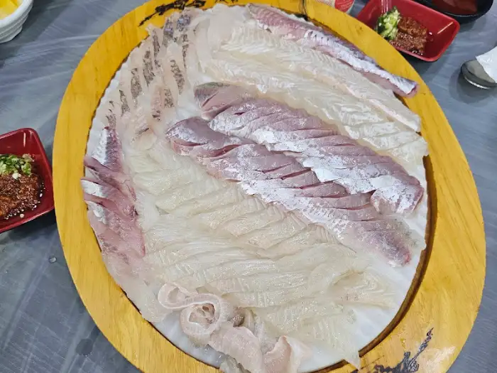 커다란 접시에 담긴 모듬회의 전체 모습. 다채로운 종류의 회가 겹겹이 쌓여 있다.