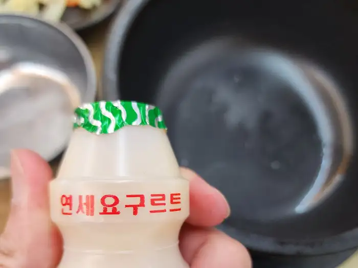 손에 들린 연세우유병과 배경의 뚝배기