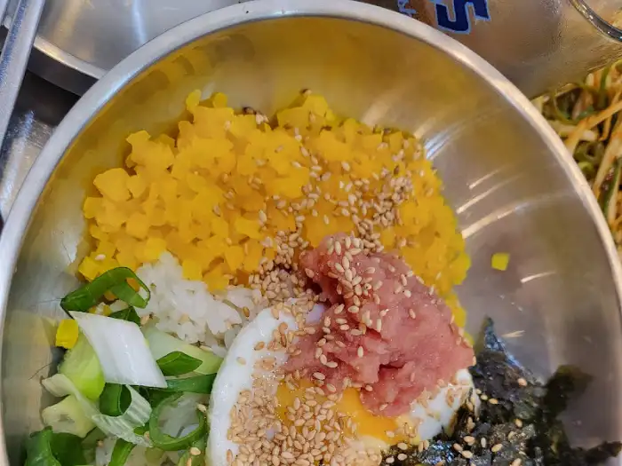 계란 프라이, 밥, 고명, 김가루 등이 푸짐하게 올라간 비빔밥 사진
