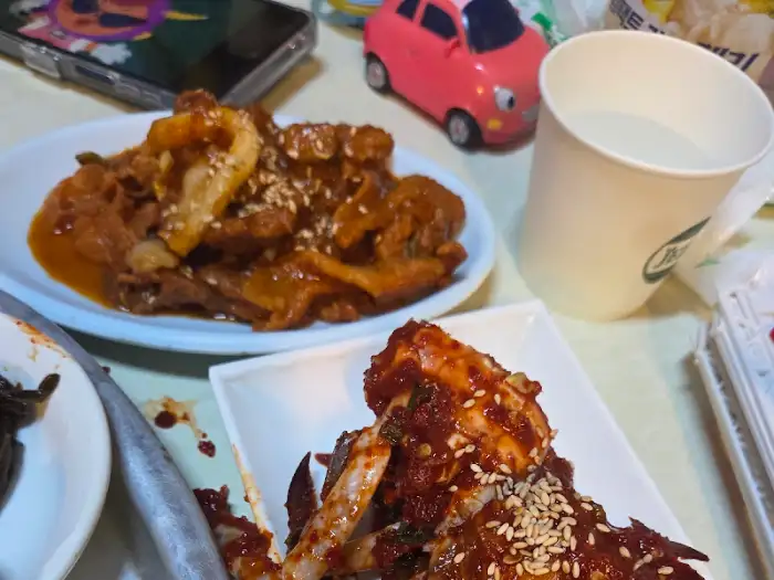양념이 잘 배인 떡갈비와 양념 명란, 그리고 밥이 담긴 접시.