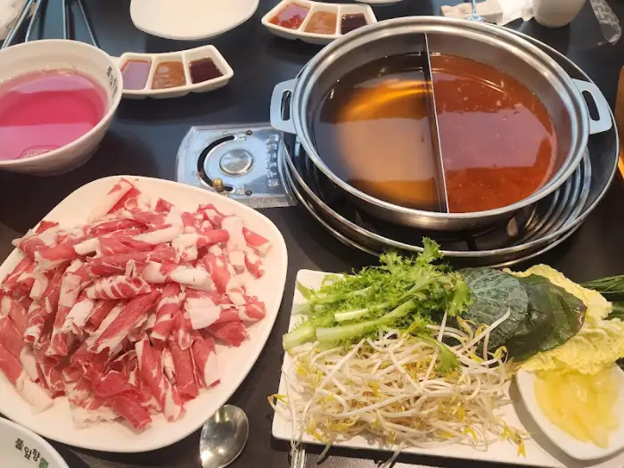 담백한 육수가 끓고 있는 샤브샤브 냄비와 신선한 고기, 야채