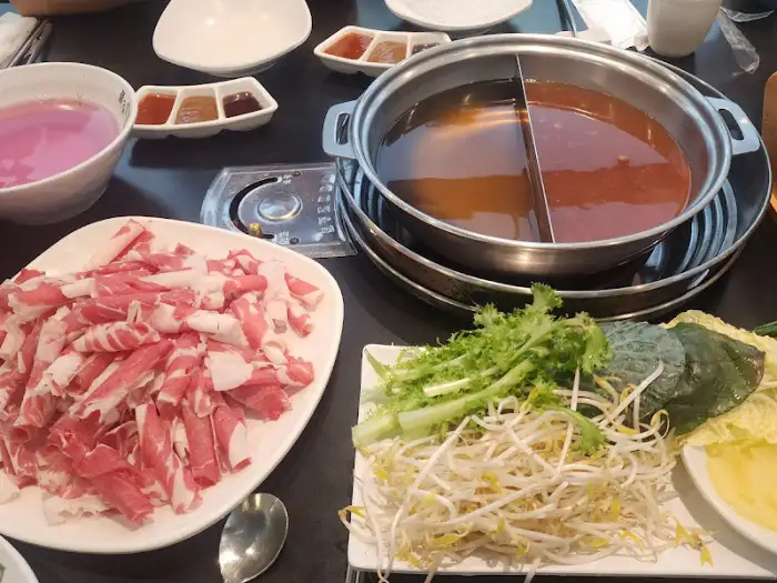 끓고 있는 샤브샤브 냄비에 다양한 채소가 담겨 있는 모습