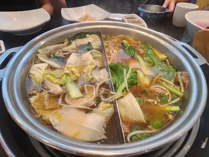 김이 모락모락 나는 샤브샤브 냄비와 신선한 재료들