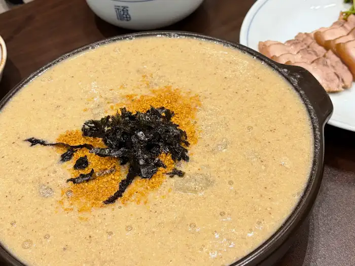 옹심이가 담긴 뚝배기 그릇이 테이블 위에 놓여 있습니다.