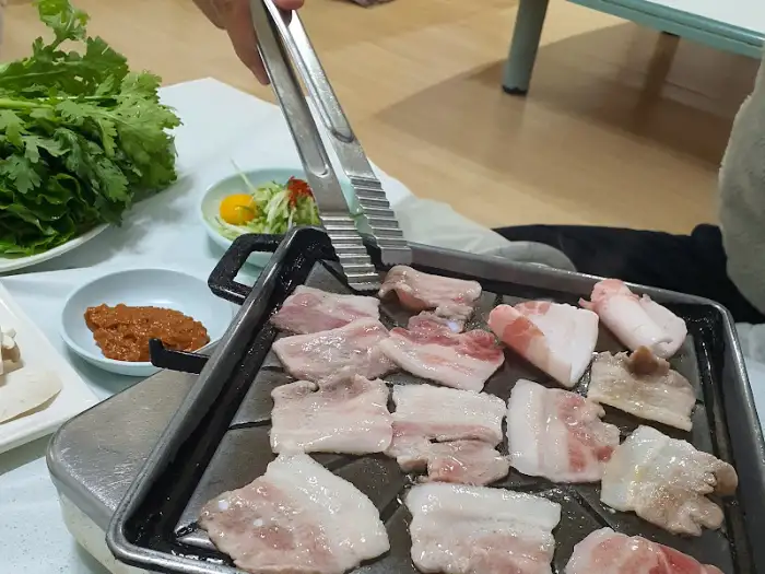 구워지고 있는 삼겹살과 곁들임 반찬