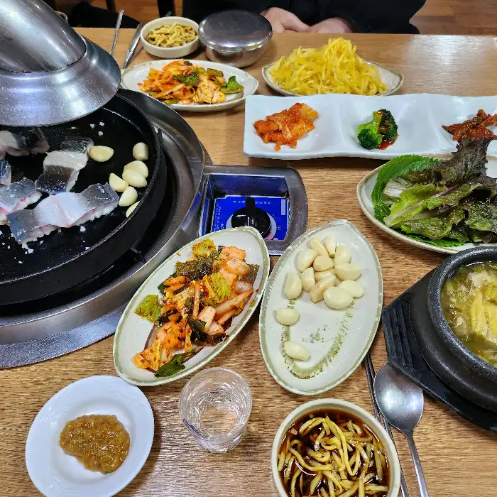 장어구이와 다양한 반찬이 차려진 테이블 사진