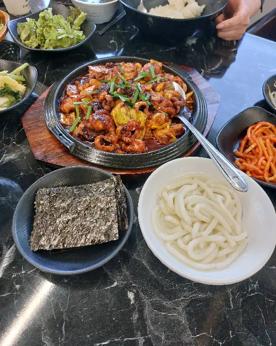 테이블 위에 차려진 쭈꾸미 요리와 곁들임 메뉴들