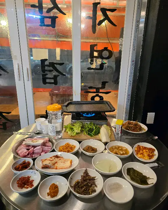테이블에 차려진 다양한 반찬과 신선한 고기