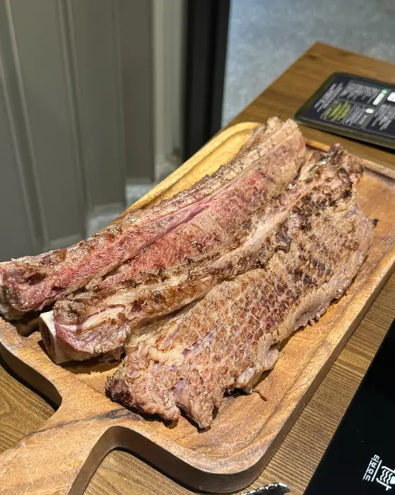 두툼한 우대갈비가 나무 도마 위에 놓여 있는 모습