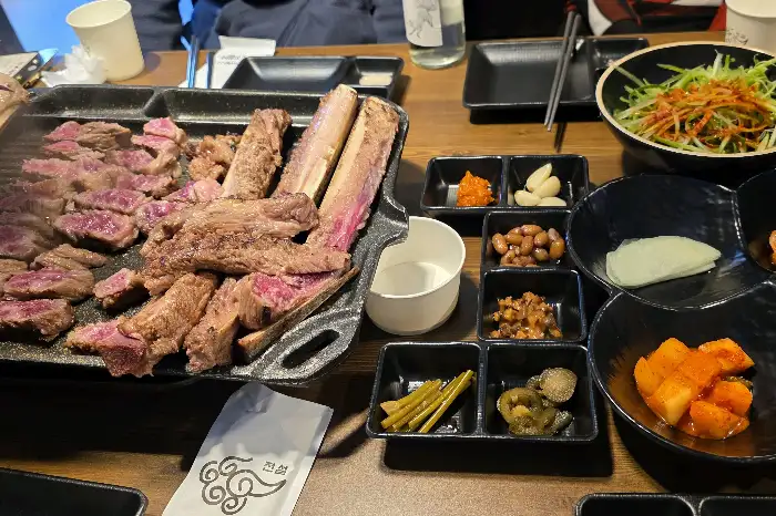 테이블에 차려진 푸짐한 고기와 밑반찬들