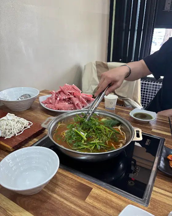 집게로 집어 올리는 얇게 썬 소고기