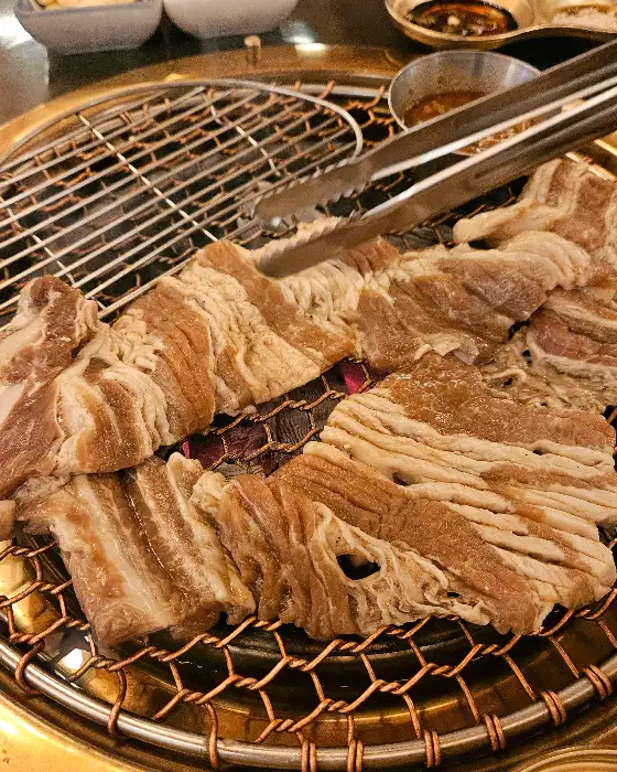 두툼하고 먹음직스러운 꼬들목살이 불판 위에서 익고 있는 모습