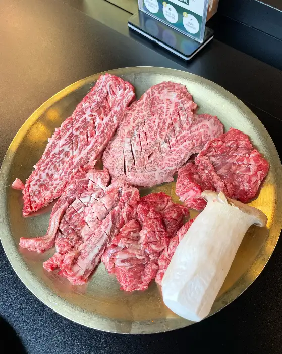 신선한 한우 등심, 갈비살, 그리고 새송이버섯으로 구성된 고기 플레이트