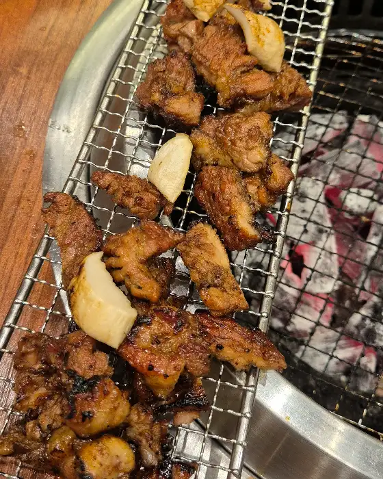 불판 위에서 맛있게 익어가는 숯불 돼지갈비