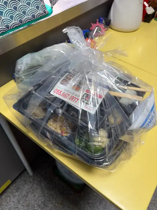 포장된 회와 밑반찬이 담긴 봉투