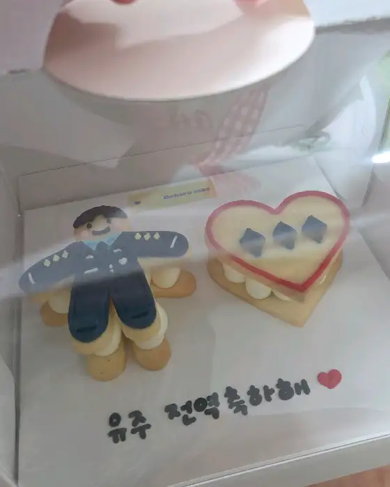 군복을 입은 캐릭터와 하트 모양 케이크