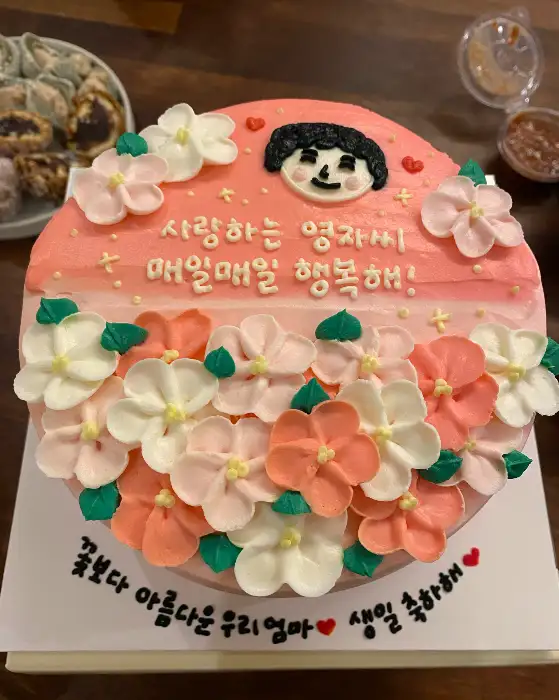 꽃 장식이 풍성한 분홍색 케이크