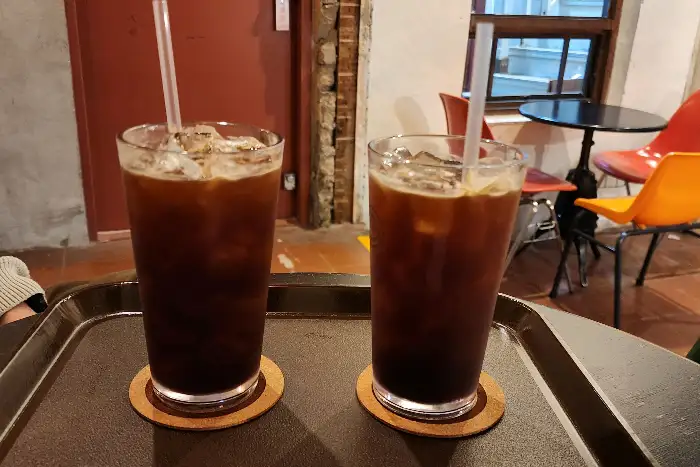 브라운핸즈 백제 내부 테이블 위에 놓인 두 잔의 아이스 아메리카노