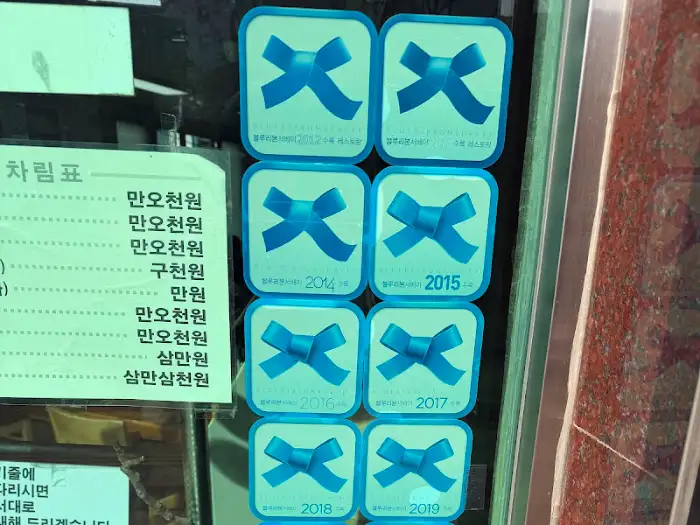 창문에 붙은 파란색 리본 인증패 사진