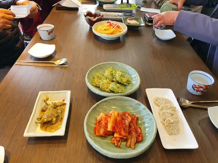 넓은 테이블에 여러 사람이 둘러앉아 식사하는 모습