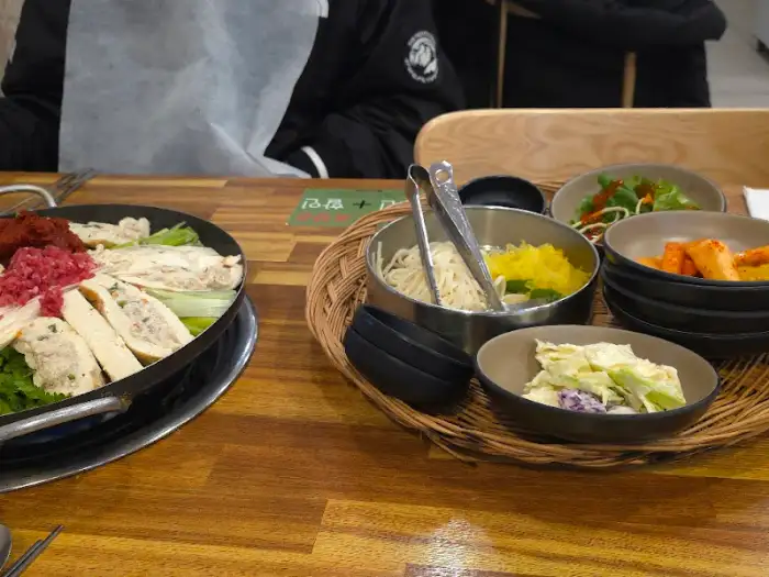 식탁 위 만두전골과 밥, 곁들임 찬들