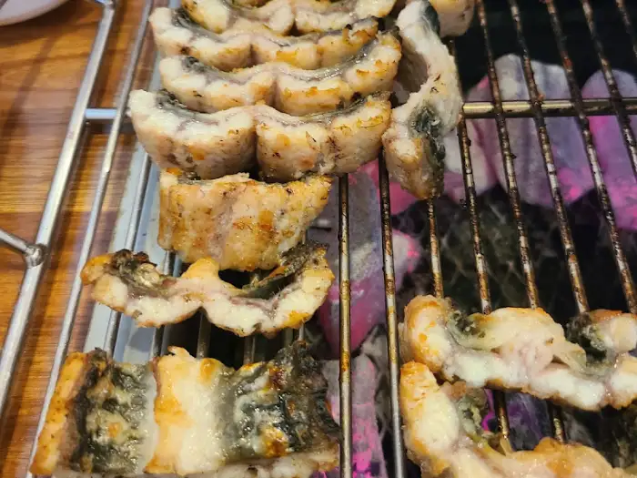 먹기 좋게 잘려 숯불 위에서 구워지는 장어 조각들