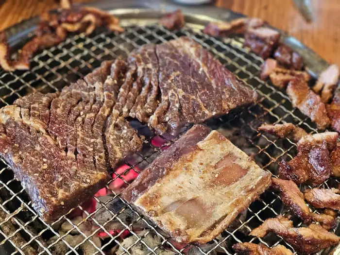 숯불 위에서 노릇하게 익어가는 돼지갈비