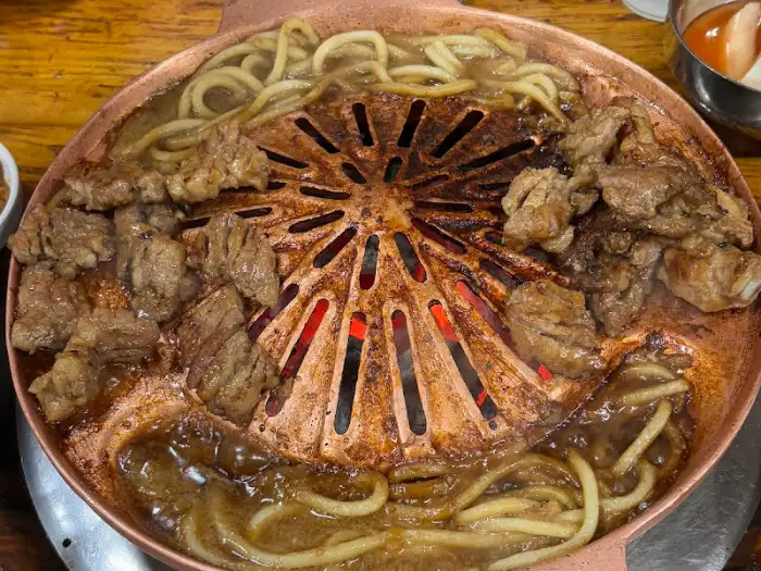 팬에 가득 담긴 돼지갈비와 우동사리