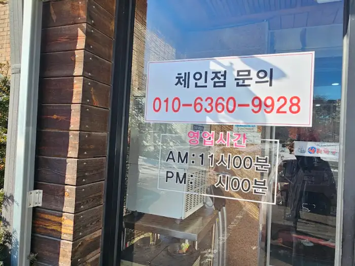 가게 입구 유리창에 부착된 영업시간 안내