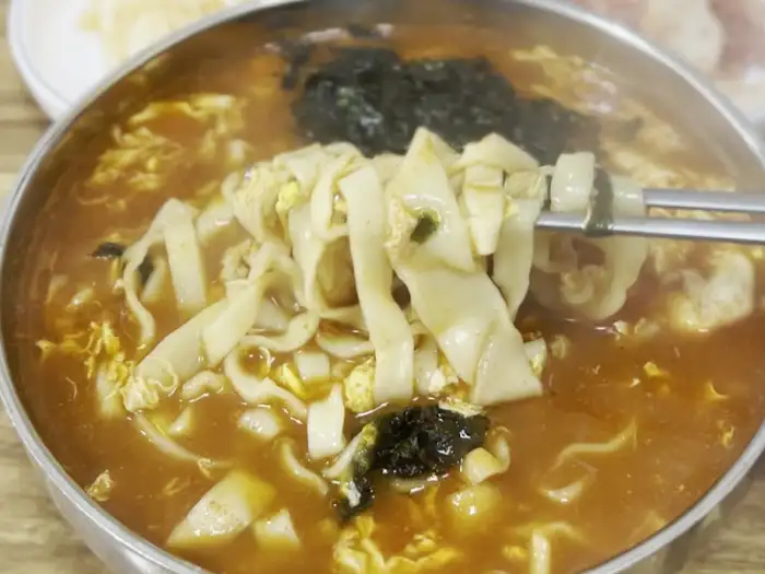 장칼국수에 김가루와 함께 면발을 집어 올리는 모습