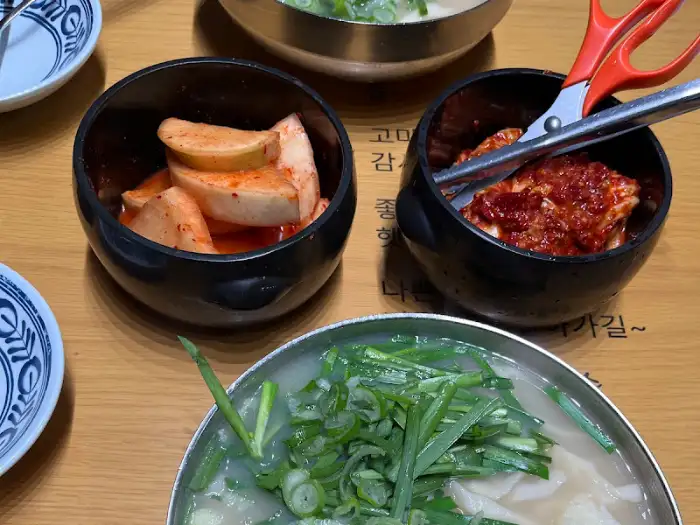 테이블에 놓인 김치와 깍두기, 그리고 가위와 집게.