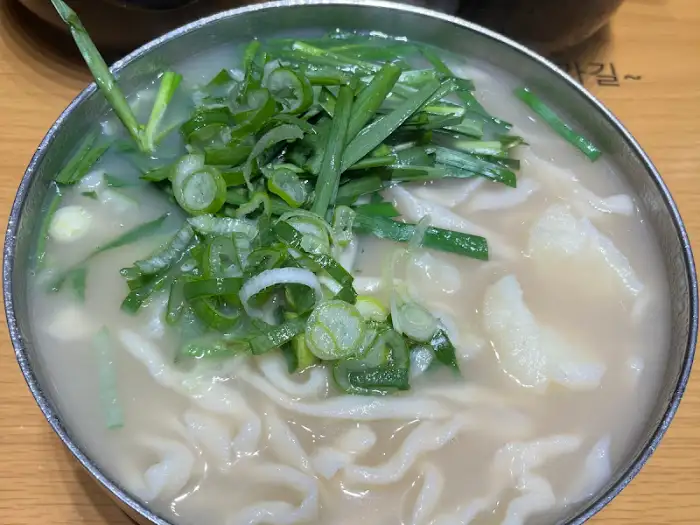 칼국수 면발과 맑은 국물이 돋보이는 클로즈업 사진.