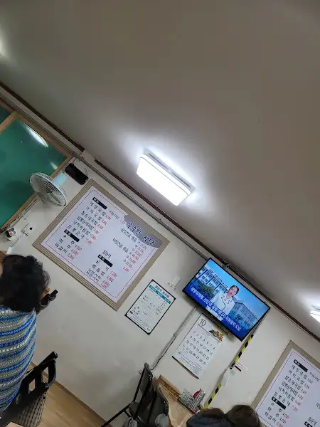 벽에 걸린 메뉴판과 TV 모습