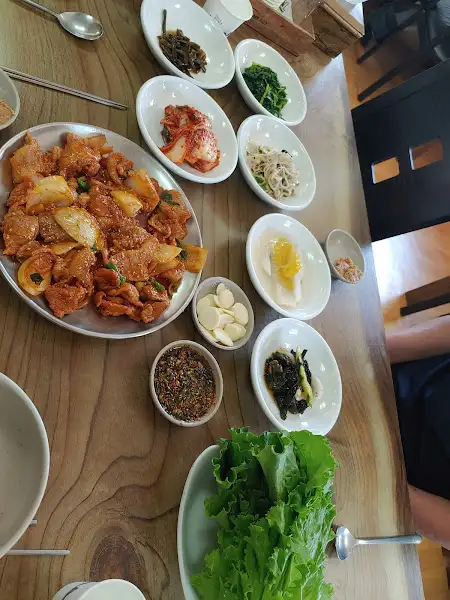 테이블에 놓인 다양한 밑반찬과 쌈 채소