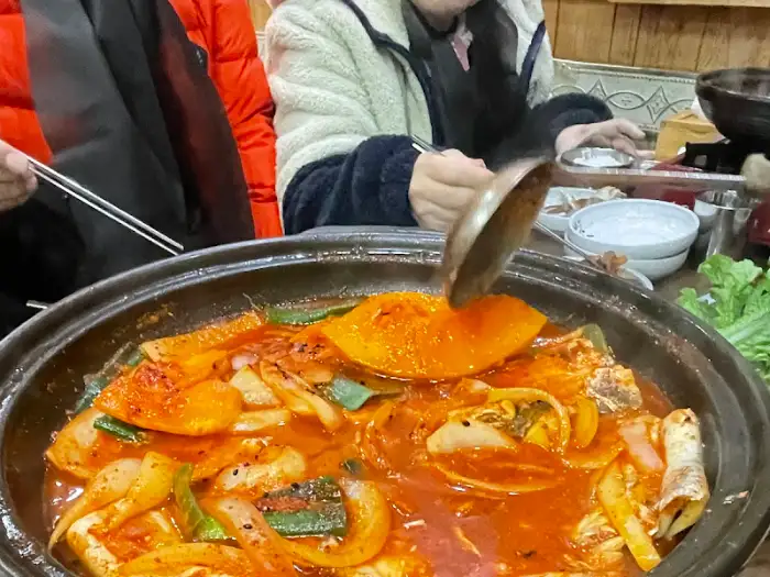 고등어 쌈밥을 국자로 뜨는 모습