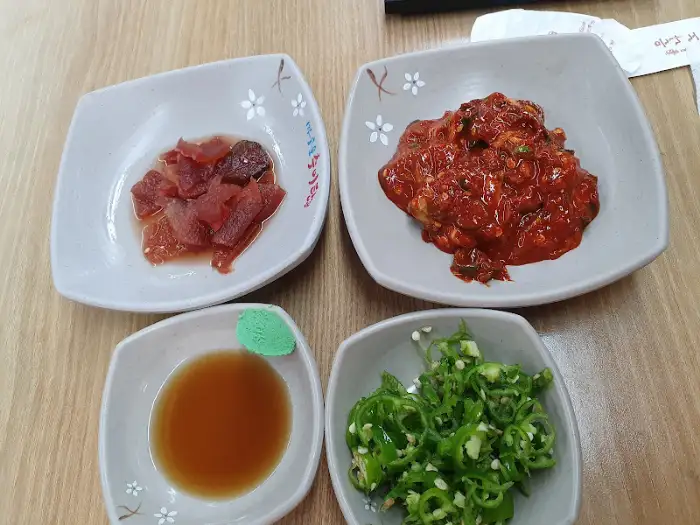 정갈한 밑반찬 구성 (어리굴젓, 고추, 소스 등)