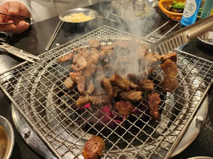 숯불 위에서 익어가는 소고기와 피어오르는 연기