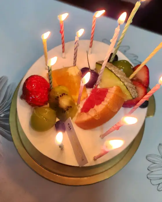 생크림 케이크에 꽂힌 초에 불이 붙어 있는 모습