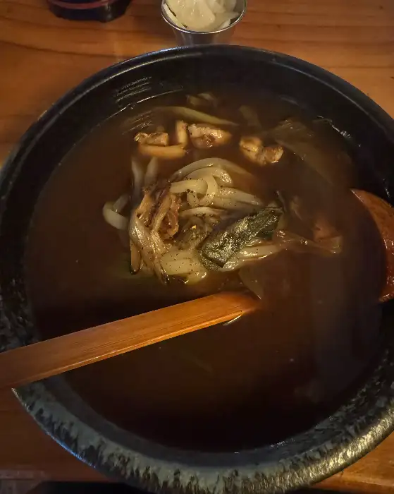 겐로쿠우동의 다른 우동 메뉴 사진. 닭고기 토핑과 채소가 들어있는 따뜻한 국물의 우동이다.