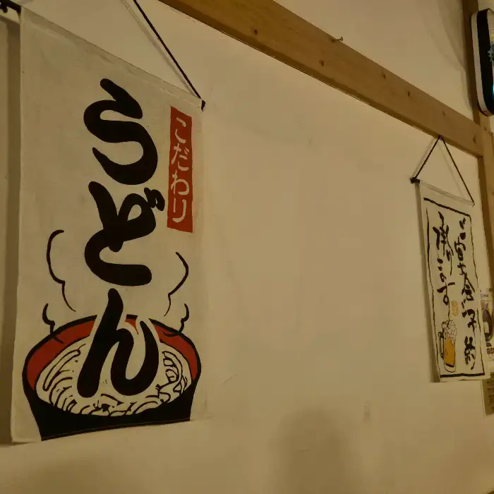 겐로쿠우동 매장 벽에 걸린 일본풍 붓글씨 디자인의 현수막. 우동 그림과 함께 '우동'이라는 글자가 크게 쓰여 있다.
