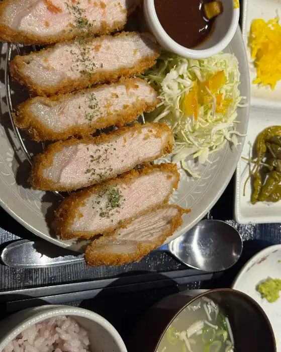 황금빛으로 바삭하게 튀겨진 돈까스 단면. 핑크빛의 부드러운 속살이 먹음직스럽다.