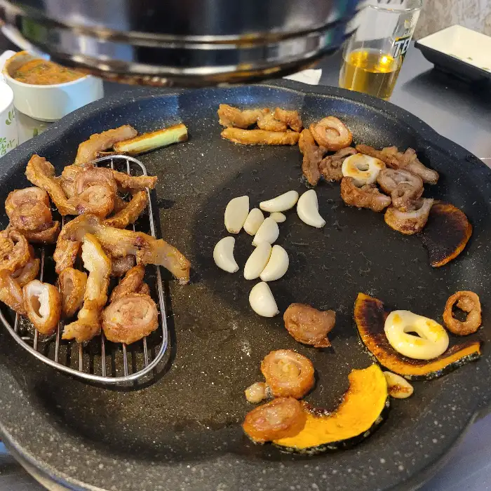 막창과 함께 불판에 구워지는 마늘과 호박