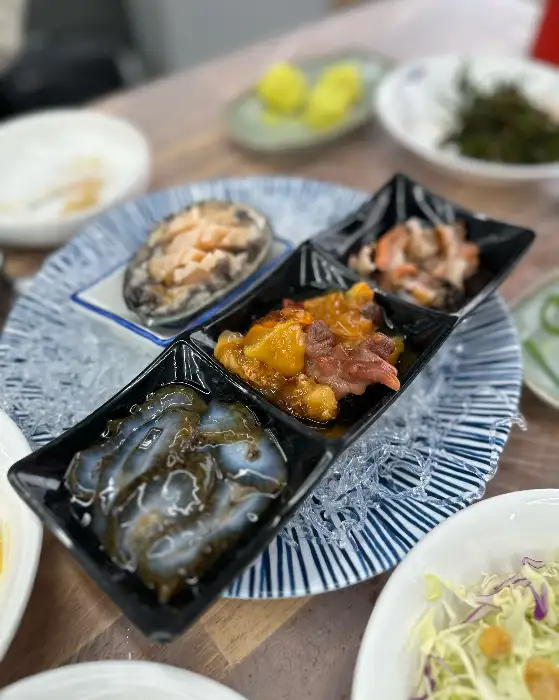 정갈하게 담긴 전복과 해산물 요리