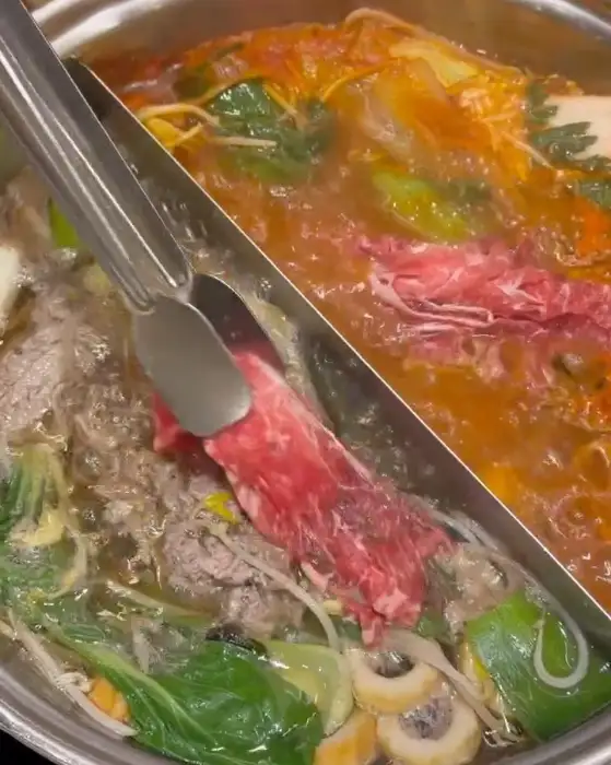 집게로 집어 올린 익힌 고기