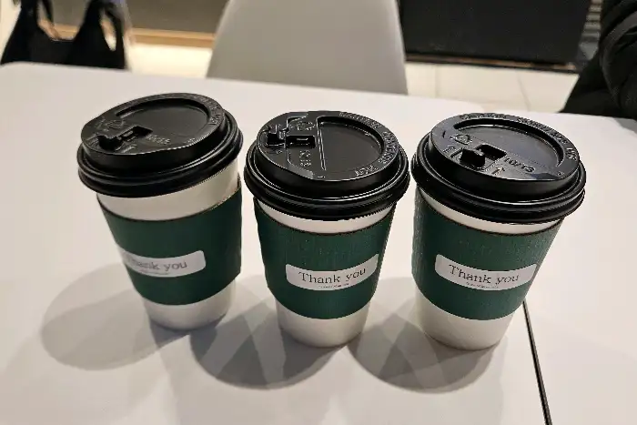 세 개의 테이크아웃 컵이 나란히 놓여 있는 모습