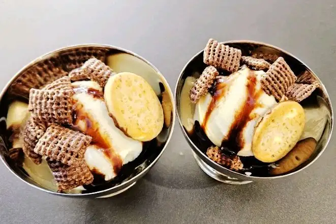 두 개의 컵에 담긴 빙수, 빵 조각과 소스가 올라가 있음