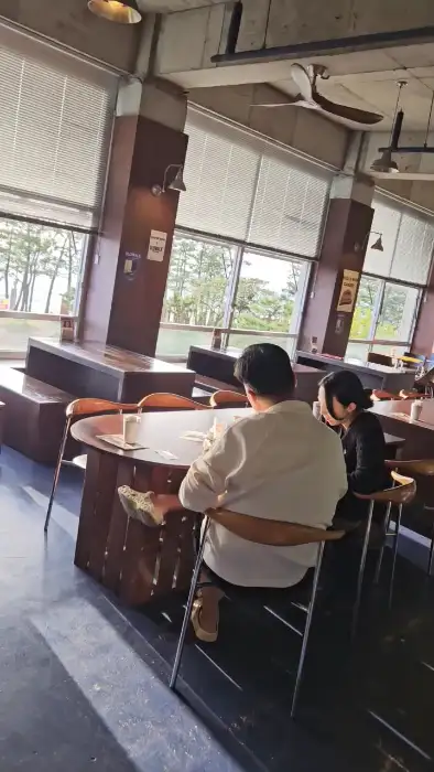 창가 좌석에서 바라본 바다 풍경과 매장 내부 모습