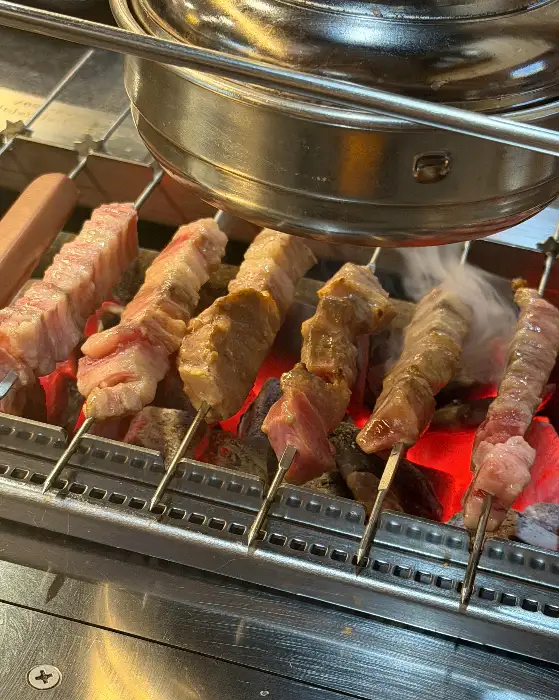 양꼬치와 양갈비 꼬치가 숯불 위에서 익어가는 모습
